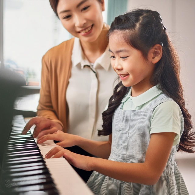 ピアノの先生と女の子がレッスンをしている画像